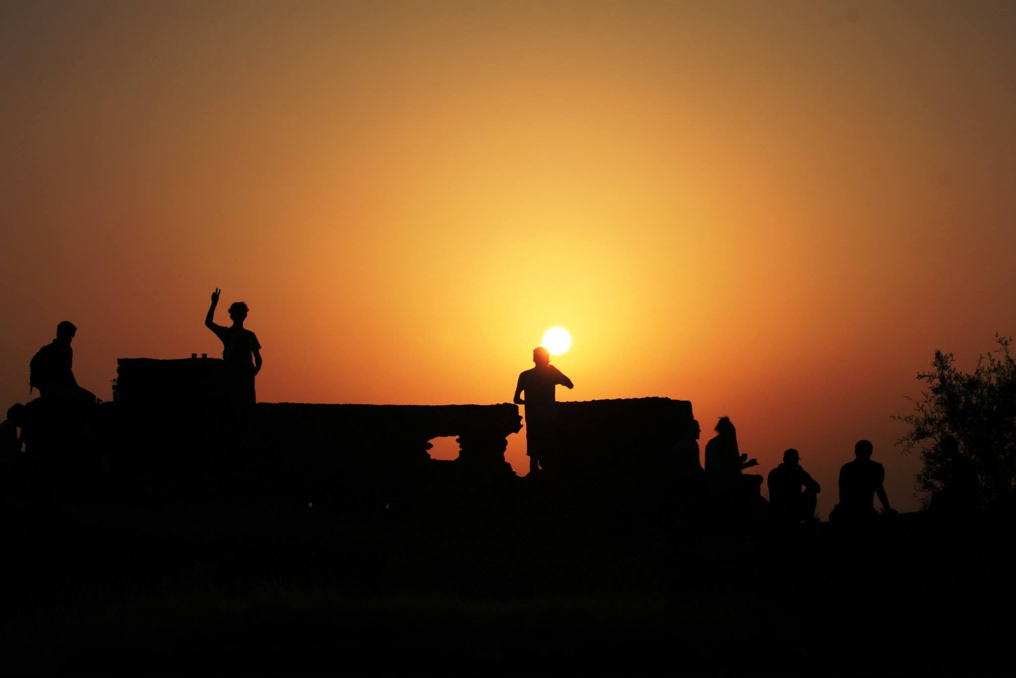 Travellers silhouetted against a sunset on the northern India trip